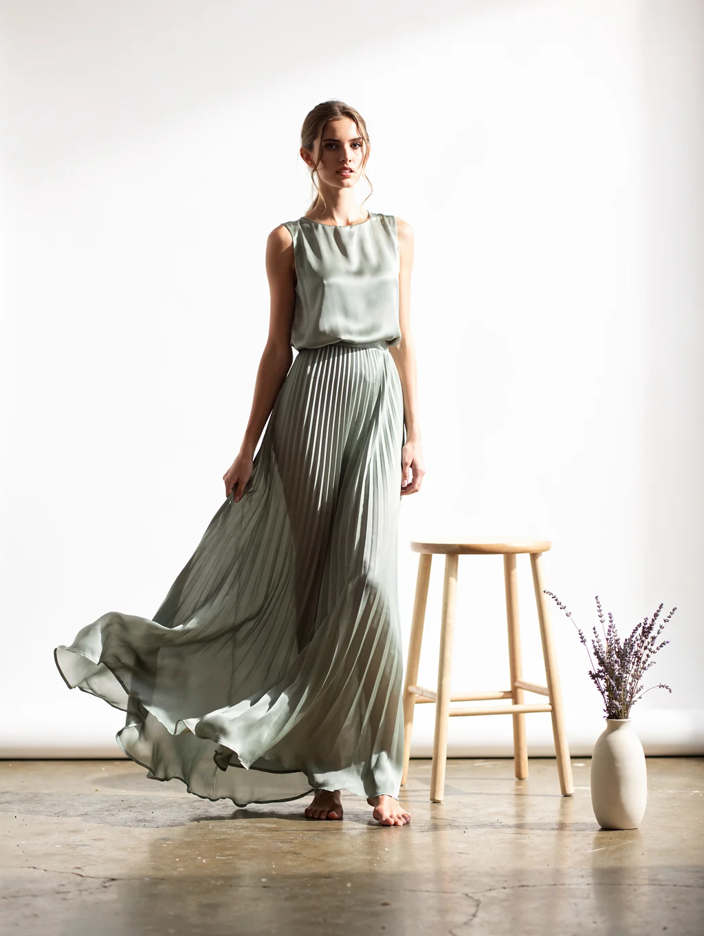 Model wearing a vibrant emerald silk wrap midi dress in sunlight
